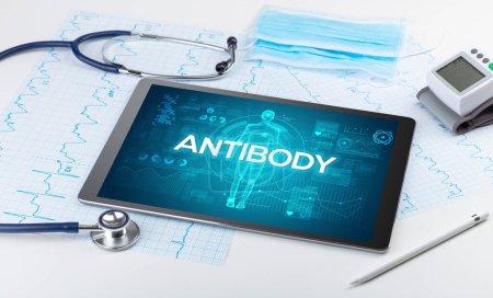 Foto de Tablet PC y herramientas médicas con inscripción ANTIBODY, concepto coronavirus - Imagen libre de derechos