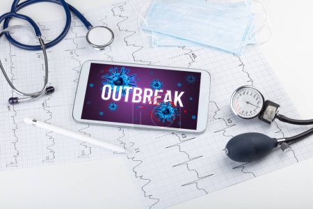 Foto de Tablet PC y herramientas médicas en superficie blanca con inscripción OUTBREAK, concepto pandémico - Imagen libre de derechos