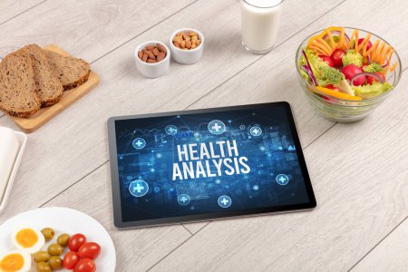 HEALTH ANALYSIS concept in tablet pc with healthy food around, top view