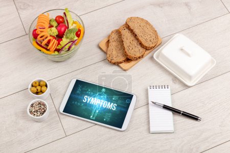 Photo for SYMPTOMS concept in tablet with fruits, top view - Royalty Free Image