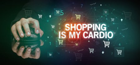hand holding wireless peripheral with SHOPPING IS MY CARDIO inscription, online shopping concept