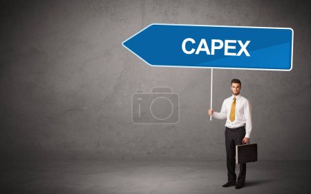 Young business person in casual holding road sign with CAPEX inscription, new business direction concept