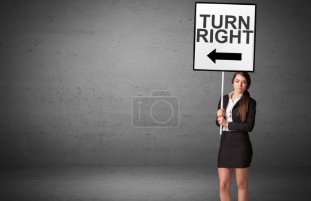 Téléchargez les photos : Homme d'affaires tenant un panneau de signalisation avec inscription TOUR À DROITE, nouveau concept d'idée - en image libre de droit
