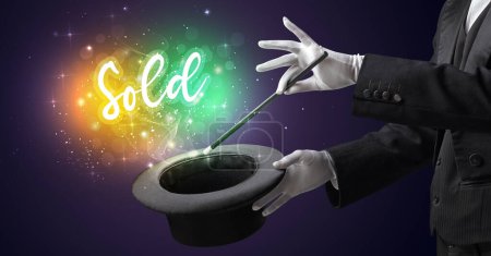 Téléchargez les photos : Main de magicien conjure avec baguette magique Vendu inscription, concept shopping - en image libre de droit