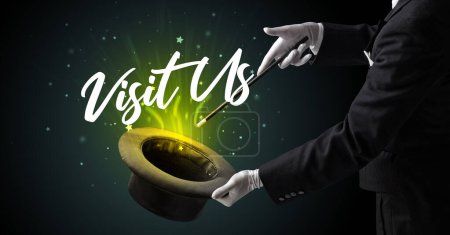 Magician is showing magic trick with Visit Us inscription, traveling concept