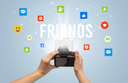 Téléchargez les photos : Utiliser la caméra pour capturer du contenu de médias sociaux avec l'inscription FRIENDS, concept de contenu de médias sociaux - en image libre de droit