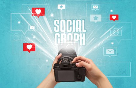 Téléchargez les photos : Gros plan d'une main prenant des photos avec inscription SOCIAL GRAPH, concept de médias sociaux - en image libre de droit
