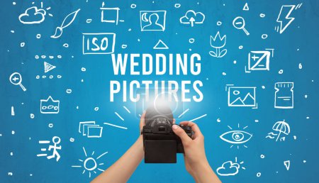 Hand taking picture with digital camera and WEDDING PICTURES inscription, camera settings concept