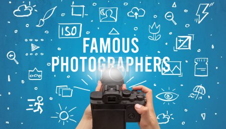 Foto de Fotografía a mano con cámara digital e inscripción FAMOUS PHOTOGRAPHERS, concepto de ajustes de cámara - Imagen libre de derechos