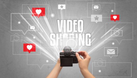 Nahaufnahme einer Hand beim Fotografieren mit VIDEO SHARING-Aufschrift, Social-Media-Konzept