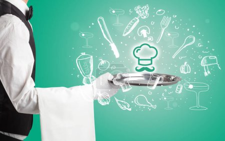 Foto de Camarero sosteniendo bandeja de plata con iconos de chef maestros saliendo de ella, concepto de comida saludable - Imagen libre de derechos