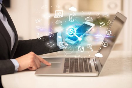 Foto de Empresario trabajando en el ordenador portátil con lupa con un signo de dólar iconos que salen de ella, concepto de negocio en crecimiento - Imagen libre de derechos