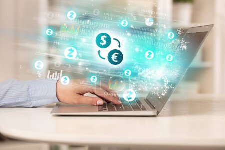 Young man watching stock market on laptop with dollar - euro exchange icons, forex concept