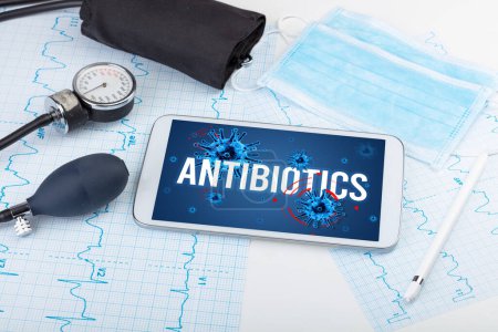 Photo for Tablet pc and doctor tools on white surface with ANTIBIOTICS inscription, pandemic concept - Royalty Free Image