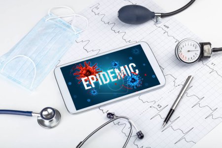 Téléchargez les photos : Tablette pc et outils médicaux sur surface blanche avec inscription EPIDEMIC, concept pandémique - en image libre de droit