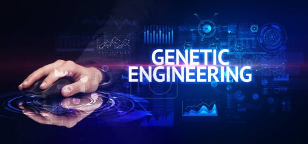 Photo for Hand holding wireless peripheral with GENETIC ENGINEERING inscription, modern technology concept - Royalty Free Image
