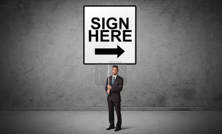 business person holding a traffic sign with SIGN HERE inscription, new idea concept
