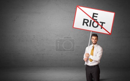 Téléchargez les photos : Homme d'affaires tenant un panneau de signalisation avec inscription E RIOT, nouveau concept d'idée - en image libre de droit