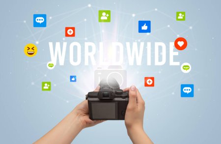 Téléchargez les photos : Utiliser la caméra pour capturer du contenu de médias sociaux avec l'inscription WORLDWIDE, concept de contenu de médias sociaux - en image libre de droit