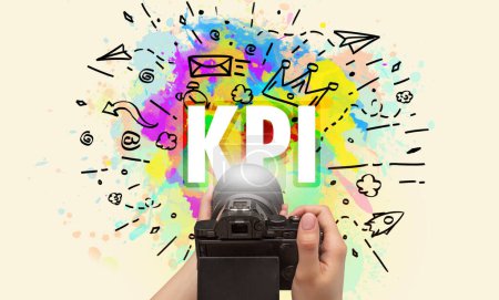 Téléchargez les photos : Gros plan d'un appareil photo numérique à main avec dessin abstrait et inscription KPI - en image libre de droit