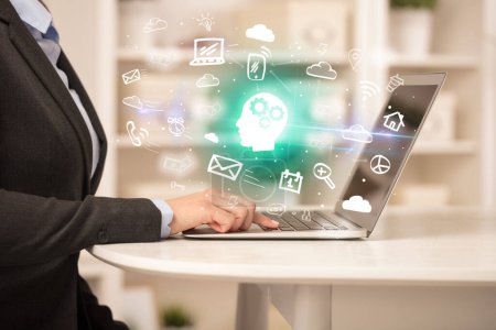 Foto de Empresario trabajando en el ordenador portátil con el hombre pensando iconos que salen de ella, concepto de negocio creciente - Imagen libre de derechos