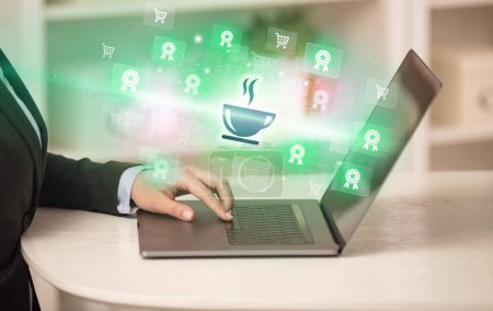 Téléchargez les photos : Homme d'affaires travaillant sur ordinateur portable avec des icônes de café qui en ressortent, concept d'entreprise réussi - en image libre de droit