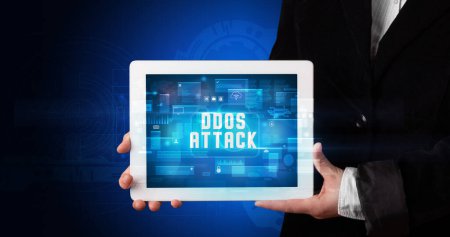 Photo for Young business person working on tablet and shows the digital sign: DDOS ATTACK - Royalty Free Image