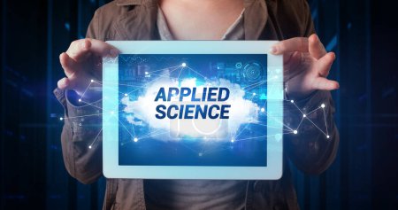 Photo for Young business person working on tablet and shows the inscription: APPLIED SCIENCE - Royalty Free Image