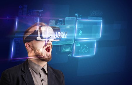 Foto de Hombre de negocios mirando a través de gafas de realidad virtual con inscripción CLIMATE CHANGE, concepto de nueva tecnología - Imagen libre de derechos