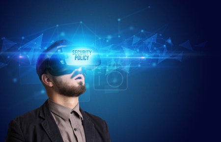 Geschäftsmann blickt durch Virtual-Reality-Brille mit SICHERHEITSPOLITIK-Aufschrift, Cyber-Sicherheitskonzept