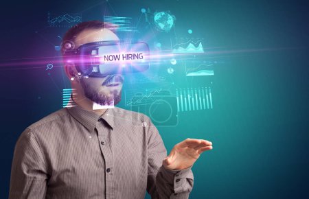 Photo for Businessman looking through Virtual Reality glasses with NOW HIRING inscription, new business concept - Royalty Free Image