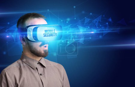 Foto de Hombre de negocios mirando a través de gafas de realidad virtual con inscripción MOBILE SECURITY, concepto de seguridad cibernética - Imagen libre de derechos