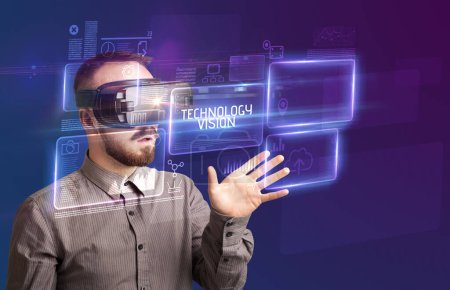 Téléchargez les photos : Homme d'affaires regardant à travers des lunettes de réalité virtuelle avec inscription TECHNOLOGY VISION, nouveau concept technologique - en image libre de droit