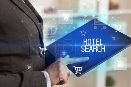 Young person makes a purchase through online shopping application with HOTEL SEARCH inscription