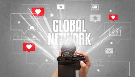 Téléchargez les photos : Gros plan d'une main prenant des photos avec inscription GLOBAL NETWORK, concept de médias sociaux - en image libre de droit