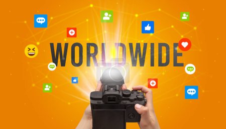 Téléchargez les photos : Utiliser la caméra pour capturer du contenu de médias sociaux avec l'inscription WORLDWIDE, concept de contenu de médias sociaux - en image libre de droit