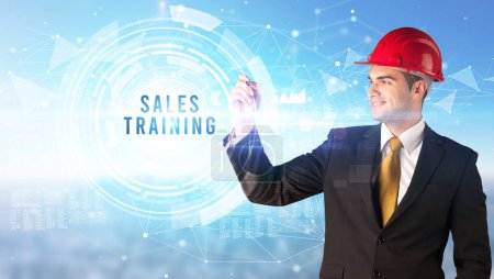 Photo for Handsome businessman with helmet drawing SALES TRAINING inscription, contruction business concept - Royalty Free Image