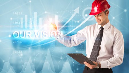 Young businessman with helmet drawing OUR VISION inscription, modern business technology concept concept