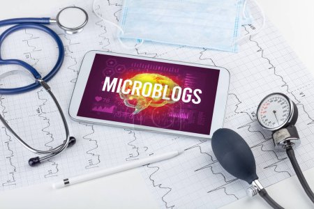 Téléchargez les photos : Tablette PC et outils médicaux avec inscription MICROBLOGS, concept de distanciation sociale - en image libre de droit