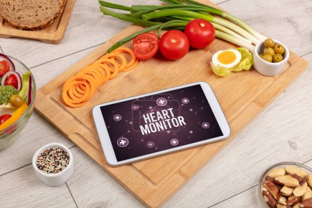 Téléchargez les photos : Concept HEART MONITOR en comprimé pc avec des aliments sains autour, vue du dessus - en image libre de droit