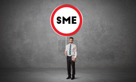 Téléchargez les photos : Jeune homme d'affaires holdig panneau de signalisation avec abréviation PME, concept de solution technologique - en image libre de droit