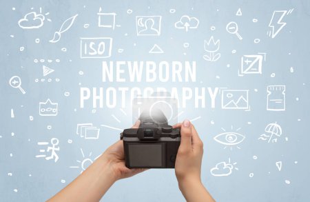 Photo for Hand taking picture with digital camera and NEWBORN PHOTOGRAPHY inscription, camera settings concept - Royalty Free Image