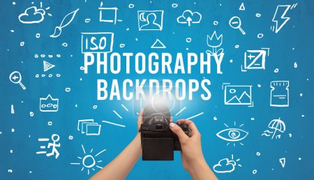 Photo for Hand taking picture with digital camera and PHOTOGRAPHY BACKDROPS inscription, camera settings concept - Royalty Free Image