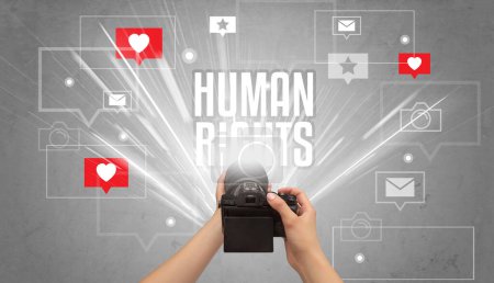 Téléchargez les photos : Gros plan d'une main prenant des photos avec inscription des droits de l'homme, concept de médias sociaux - en image libre de droit
