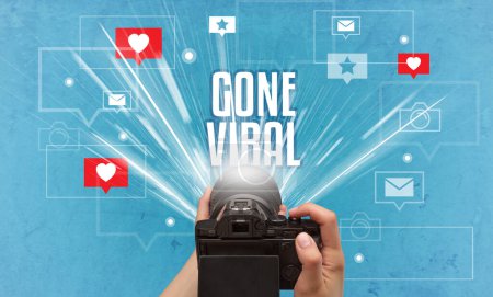 Foto de Primer plano de una mano tomando fotos con la inscripción GONE VIRAL, concepto de redes sociales - Imagen libre de derechos