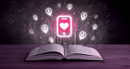 Foto de Libro abierto con smartphone con iconos del corazón arriba, concepto de redes sociales - Imagen libre de derechos