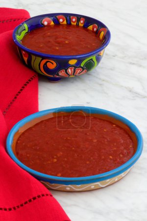Photo for Delicious, mild or fiery mexican hot sauce on traditional pottery dishes. - Royalty Free Image