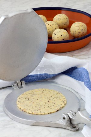 Téléchargez les photos : Pâte de tortilla de maïs mexicaine et tortillas, faite à la main avec une presse à tortilla. - en image libre de droit