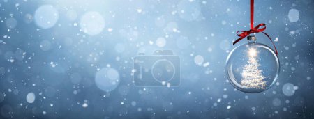 Téléchargez les photos : Arbre de Noël lumineux dans une boule sur fond bleu neigeux avec espace de copie - en image libre de droit