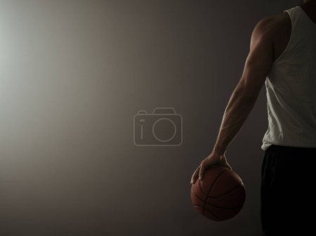 Vista trasera de un jugador de baloncesto en el gimnasio vacío con espacio para copiar